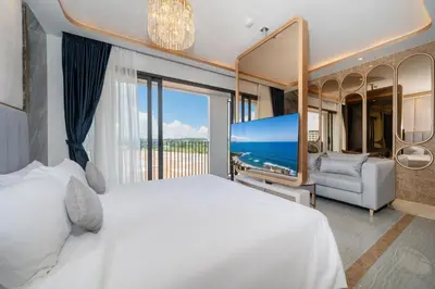 a bedroom with a large white bed and a large window at Apartments Bellevue Lagoon Phuket near Laguna in Phuket