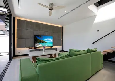 a living room with a green couch and a tv at Sleek Designed Sunset Garden Villa 05 - 4 BR with Salt Private Pool 12M in Ban Saiyuan (1)