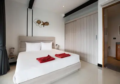 a bedroom with a bed with two red pillows on it at Sleek Designed Sunset Garden Villa 05 - 4 BR with Salt Private Pool 12M in Ban Saiyuan (1)