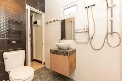 a bathroom with a toilet and a sink and a shower at KUM house in Laguna Phuket