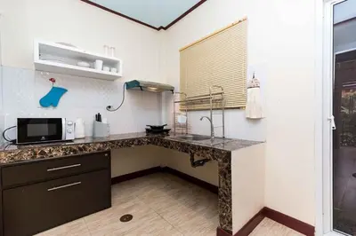a kitchen with a sink and a microwave at KUM house in Laguna Phuket
