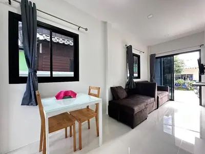a living room with a table and a couch at Layla house, Bang Tao beach in Ban Thalat Choeng Thale