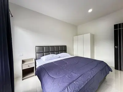 a bedroom with a large bed with a purple blanket at Layla house, Bang Tao beach in Ban Thalat Choeng Thale