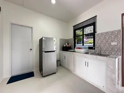 a kitchen with a refrigerator and a window at Layla house, Bang Tao beach in Ban Thalat Choeng Thale