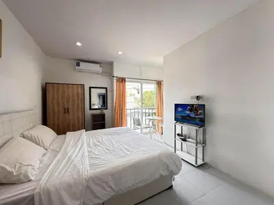 a bedroom with a white bed and a balcony at MAM house in a quiet and stylish location in Ban Thalat Choeng Thale