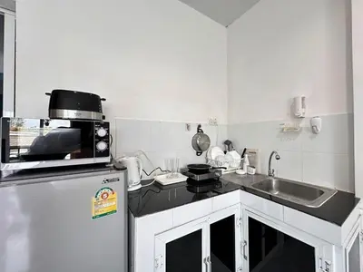 a small kitchen with a sink and a refrigerator at MAM house in a quiet and stylish location in Ban Thalat Choeng Thale