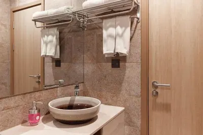 a bathroom with a bowl sink and a mirror at Cozy Apartment at Rawai with Pool Access in Phuket Town
