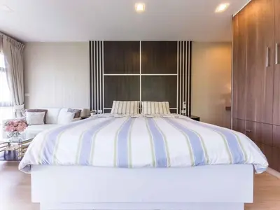 a large white bed in a bedroom with a couch at Apartments in the NICE condominium on Bang Tao Beach in Ban Thalat Choeng Thale