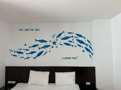 a bedroom with a bed with a group of fish on the wall at sunflower \u4e00\u5367\u7cbe\u54c1\u5927\u5e8a\u623f\u5e26\u9633\u53f0 in Patong Beach