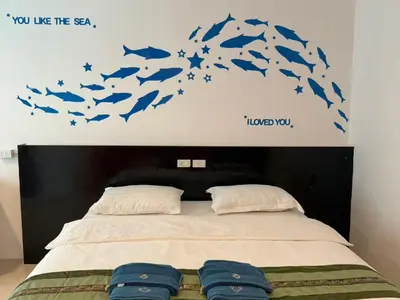 a bedroom with a bed with blue fishes on the wall at sunflower \u4e00\u5367\u7cbe\u54c1\u5927\u5e8a\u623f\u5e26\u9633\u53f0 in Patong Beach
