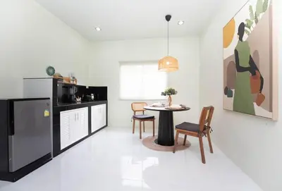 a kitchen and dining room with a table and chairs at NI houses in Ban Thalat Choeng Thale