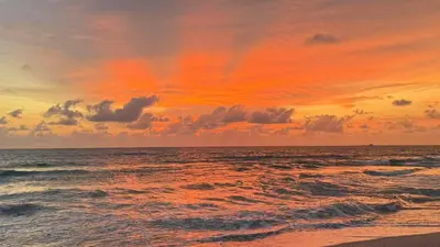 a sunset on the beach with the ocean at fruit paradise hotel in Patong Beach