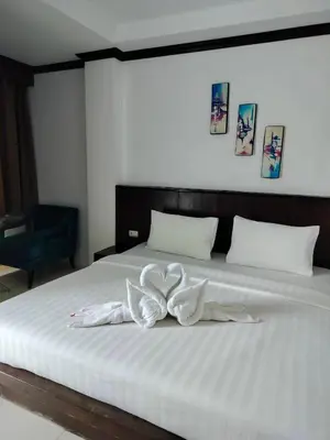a large white bed with a white bow on it at fruit paradise hotel in Patong Beach