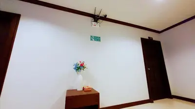 a room with a white wall with a vase of flowers at fruit paradise hotel in Patong Beach