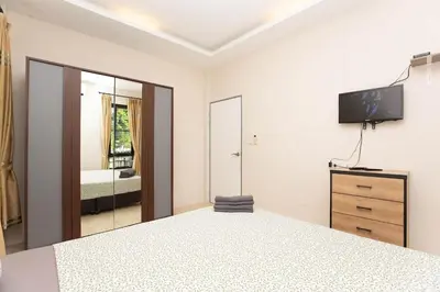 a bedroom with a bed and a tv and a mirror at House in a quiet and stylish location NU8, Bang Tao in Surin Beach
