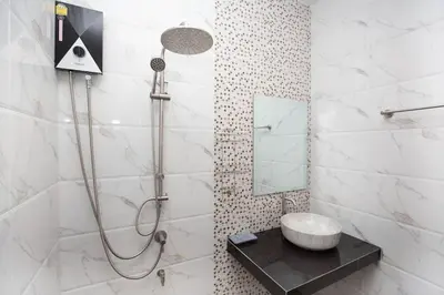 a bathroom with a shower with a sink and a mirror at Lovely OPTIC apartments on Bang Tao Beach in Ban Thalat Choeng Thale