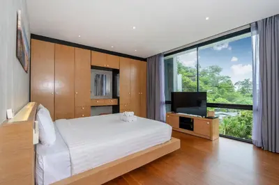 a bedroom with a bed and a flat screen tv at Peaceful retreat at The Woods Natural Park in Kamala Beach