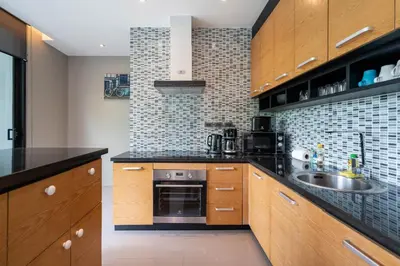 a kitchen with wooden cabinets and a sink at Peaceful retreat at The Woods Natural Park in Kamala Beach