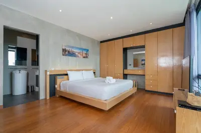 a bedroom with a large white bed and wooden cabinets at Peaceful retreat at The Woods Natural Park in Kamala Beach