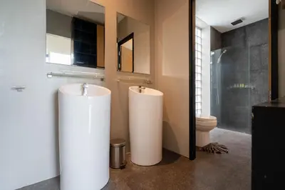 a bathroom with two white cylindrical toilets in a room at Peaceful retreat at The Woods Natural Park in Kamala Beach