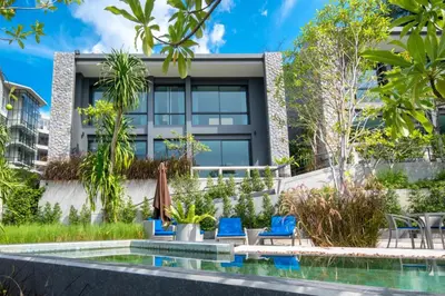 an image of a building with a swimming pool and blue chairs at Peaceful retreat at The Woods Natural Park in Kamala Beach