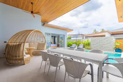 an outdoor patio with a table and chairs and a bird cage at The S Villas in Laguna Phuket