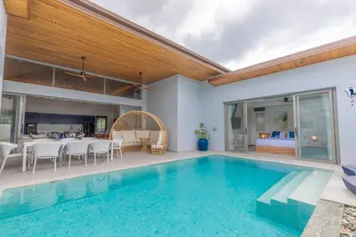 a house with a swimming pool and a dining room at The S Villas in Laguna Phuket