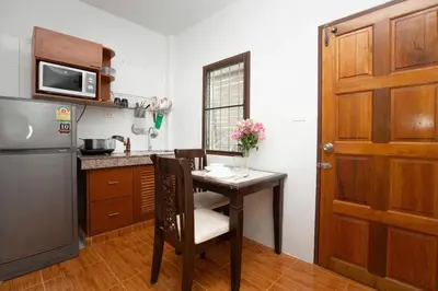 a small kitchen with a table and a refrigerator at Cozy PUY houses near Bang Tao Beach in Ban Thalat Choeng Thale