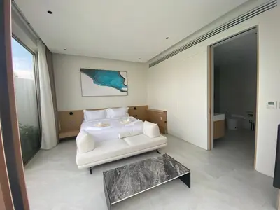 a bedroom with a white bed and a table at 4bdr New Pool Villa Bangtao by Capital Pro ASH-37 in Ban Pak Lak
