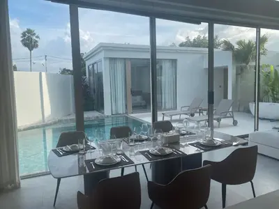 a dining room with a table with wine glasses at 4bdr New Pool Villa Bangtao by Capital Pro ASH-37 in Ban Pak Lak