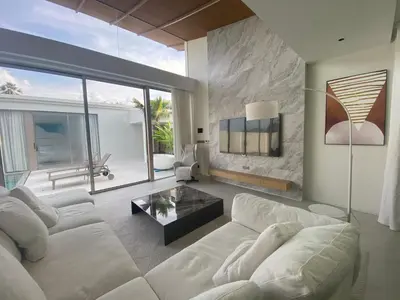a living room with a white couch and a large window at 4bdr New Pool Villa Bangtao by Capital Pro ASH-37 in Ban Pak Lak