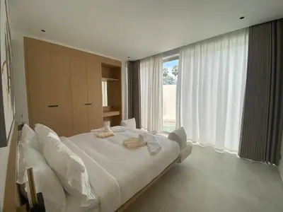 a white bed in a room with a large window at 4bdr New Pool Villa Bangtao by Capital Pro ASH-37 in Ban Pak Lak