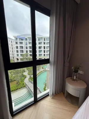 a bedroom with a large window with a view of a building at New and Stunning 1BR, The Title Legendary by UNO in Bang Tao Beach