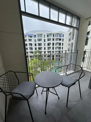 a table and two chairs on a balcony with a building at New and Stunning 1BR, The Title Legendary by UNO in Bang Tao Beach