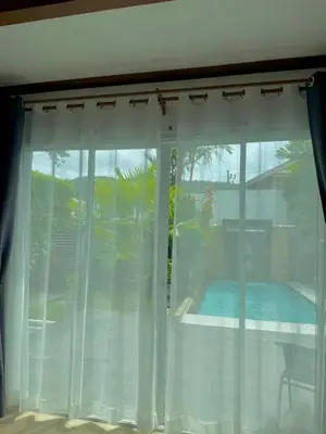a window with a view of a pool at Suriyasom Villa 5 in Thalang