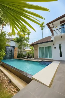 a swimming pool in front of a house at Suriyasom Villa 5 in Thalang