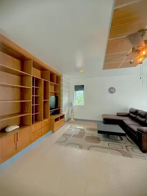 a large living room with a couch and a television at Suriyasom Villa 5 in Thalang