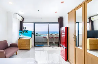 a room with a red refrigerator and a view of the ocean at OMNIAPHUKET - Sea View Patong Tower - Top Location & Sea View in Patong Beach