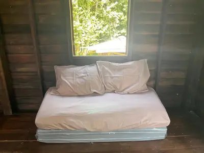 a bed with two pillows and a window in a room at Balance home happy in Ko Yao Noi