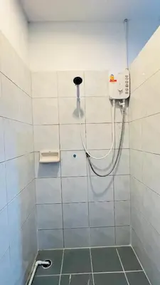 a shower with a hose attached to a wall at Daisy House Patong in Patong Beach
