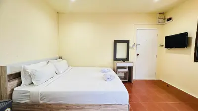 a bedroom with a large white bed and a mirror at Daisy House Patong in Patong Beach