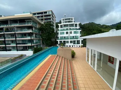 a swimming pool in front of a building at The Bay cliff By Tris in Patong Beach