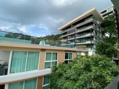 an apartment building with trees in front of it at The Bay cliff By Tris in Patong Beach