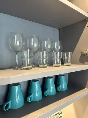 a row of wine glasses and vases on a shelf at CityGate Kamala 1 bedroom by Ere B312 in Kamala Beach