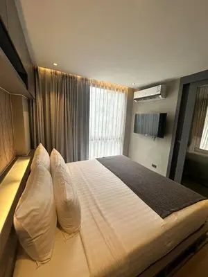 a bedroom with a bed with pillows and a window at CityGate Kamala 1 bedroom by Ere B312 in Kamala Beach