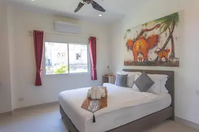 a bedroom with a bed and a painting on the wall at Luxury Seaview Villa, Infinity Pool, Sunset in Karon Beach