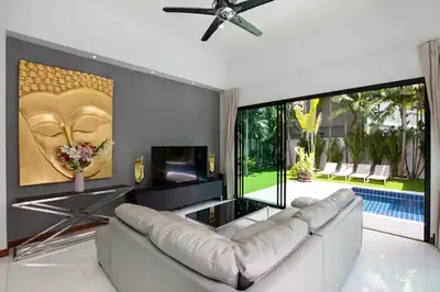 a living room with a white couch and a ceiling fan at Tropical Dream Villa in Rawai Beach