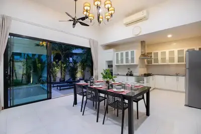 a kitchen with a table and chairs and a large window at Tropical Dream Villa in Rawai Beach