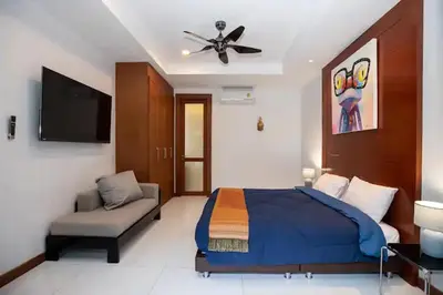 a bedroom with a bed and a fan and a couch at Tropical Dream Villa in Rawai Beach
