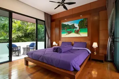 a bedroom with a purple bed and a balcony at Tropical Dream Villa in Rawai Beach